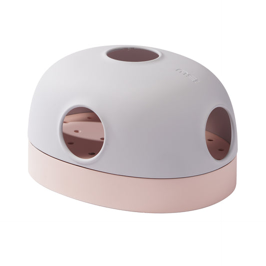A cat toy resembling a turntable with multiple holes and a two-tone color scheme of pink and white.