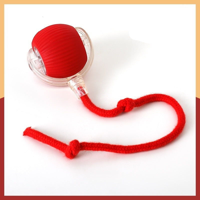 Interactive cat toy ball with a red plush tail and a cat playing with it. The toy has a rope and emits blue and purple lights indicating different modes of play.