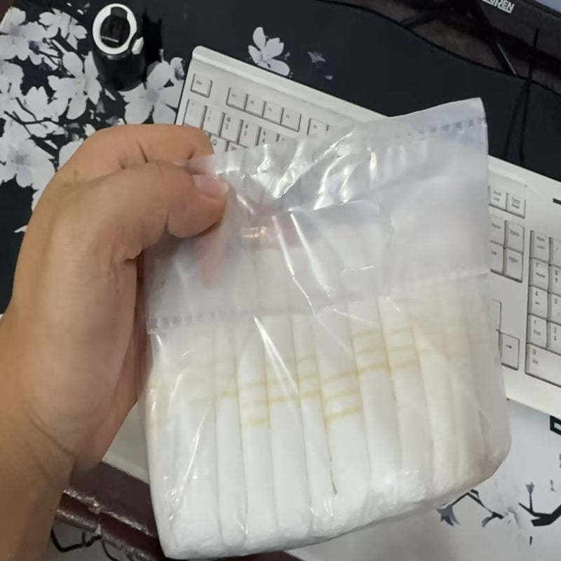 A pack of disposable pet diapers with a cartoon pattern, displayed alongside a brown dog.