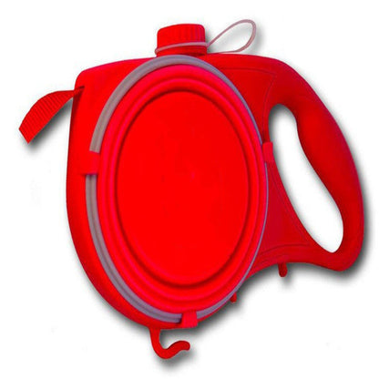 A person standing next to a dog with a retractable blue pet leash attached to the dog's collar. The leash is fully extended, and it appears to be a bright sunny day with yellow flowers in the background.