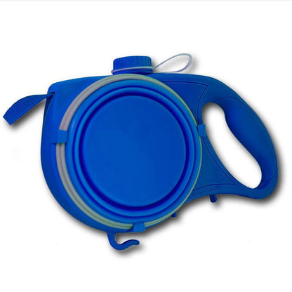 A person standing next to a dog with a retractable blue pet leash attached to the dog's collar. The leash is fully extended, and it appears to be a bright sunny day with yellow flowers in the background.