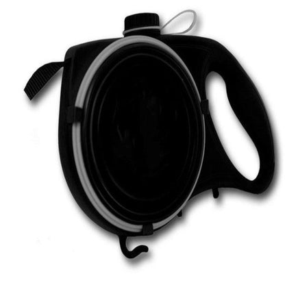 A person standing next to a dog with a retractable blue pet leash attached to the dog's collar. The leash is fully extended, and it appears to be a bright sunny day with yellow flowers in the background.