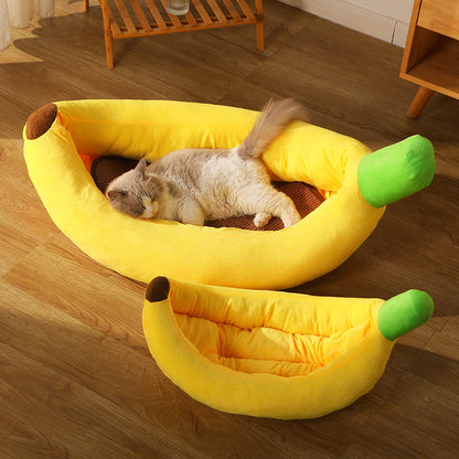 Cat lying on a banana-shaped pet bed in a room with wooden flooring.