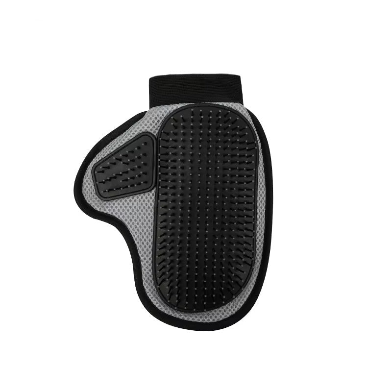 A hand wearing a black and green pet grooming glove with silicone tips, holding a clump of cat hair, next to a white cat.