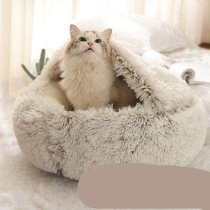 A cat resting inside a gray, hooded, plush pet bed.