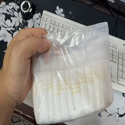 A pack of disposable pet diapers with a cartoon pattern, displayed alongside a brown dog.