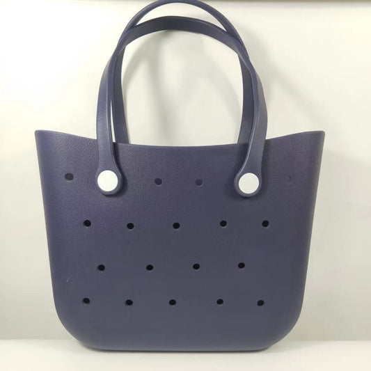 Navy blue handbag with white buttons on a light gray background