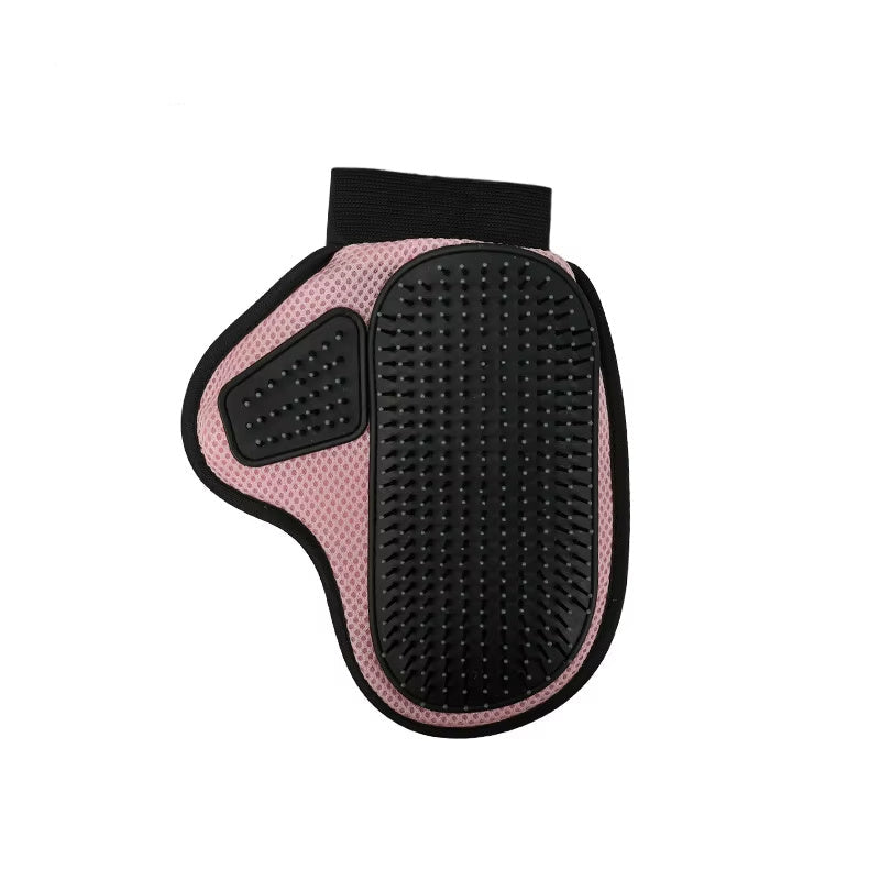 A hand wearing a black and green pet grooming glove with silicone tips, holding a clump of cat hair, next to a white cat.