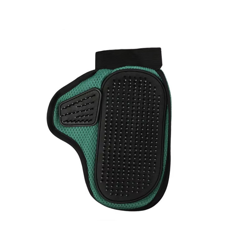 A hand wearing a black and green pet grooming glove with silicone tips, holding a clump of cat hair, next to a white cat.