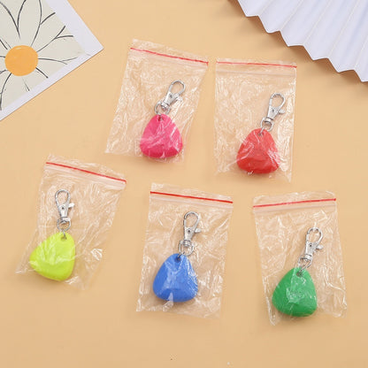 A silicone triangle pendant light in various colors shown with a dog wearing one of the pendants attached to a collar.