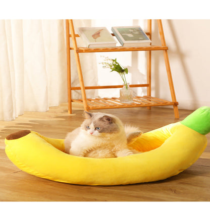 Cat lying in a banana-shaped pet bed on a wooden floor with a blurred background